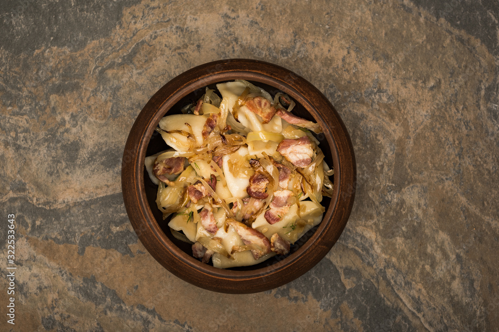 top view of delicious varenyky with cracklings on stone surface top view of delicious varenyky with cracklings on stone surface