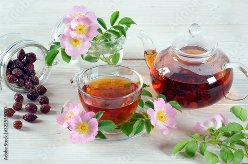 Cup and teapot tea with hip rose flowers