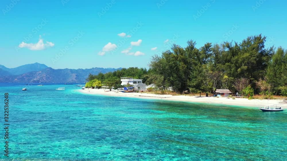 Bright sky and white clouds over mountains background, tropical islands with white sandy beach washed by crystal emerald sea water in Indonesia Bright sky and white clouds over mountains background, tropical islands with white sandy beach washed by crystal emerald sea water in Indonesia