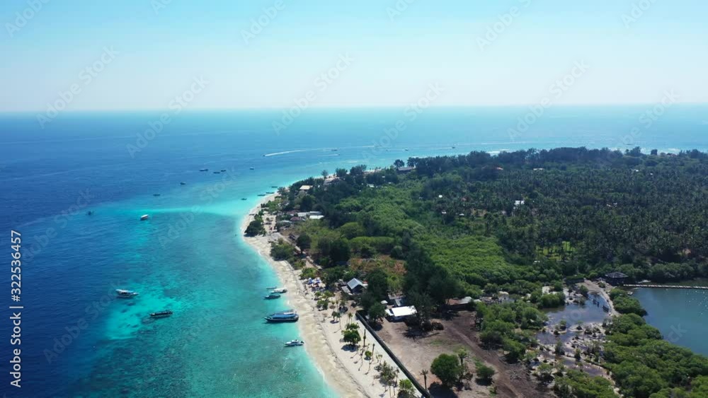 Beautiful exotic beach of tropical island with lush vegetation, surrounded by clear blue sea and turquoise lagoon in Bali Beautiful exotic beach of tropical island with lush vegetation, surrounded by clear blue sea and turquoise lagoon in Bali