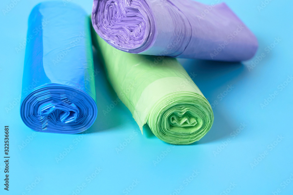 Heap of rolls of disposable plastic garbage bag on blue background. Close-up Heap of rolls of disposable plastic garbage bag on blue background. Close-up