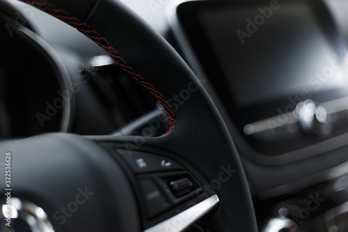 Leather car interior. Modern car illuminated dashboard. Luxurious car instrument cluster. Close up shot of automobile instrument panel. Modern car interior dashboard and steering wheel © svetlichniy_igor