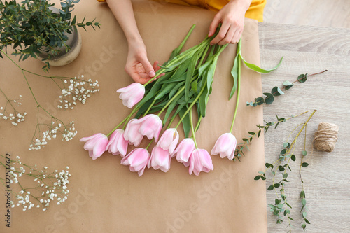 Принти на полотні Unrecognizable young woman wearing mustard yellow shirt making a beautiful bouquet of flowers