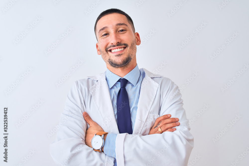 Young doctor man wearing white coat over isolated background happy face smiling with crossed arms looking at the camera. Positive person. Young doctor man wearing white coat over isolated background happy face smiling with crossed arms looking at the camera. Positive person.