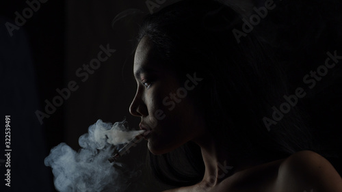Принти на полотні Asian woman inhaling and cigarette vaping