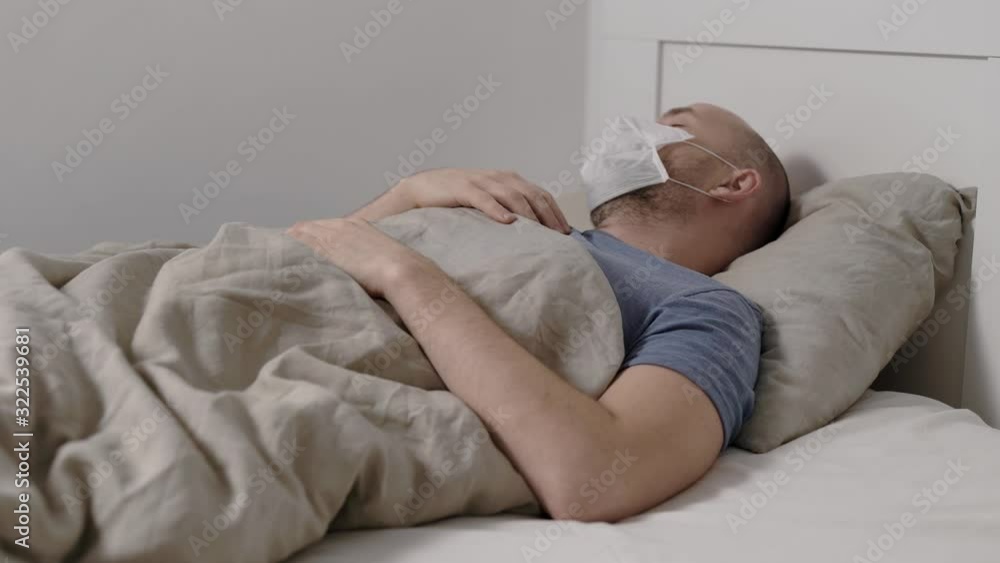 man is suffering by fever, high temperature and cough lying in bed during seasonal epidemic of flu and respiratory infections man is suffering by fever, high temperature and cough lying in bed during seasonal epidemic of flu and respiratory infections