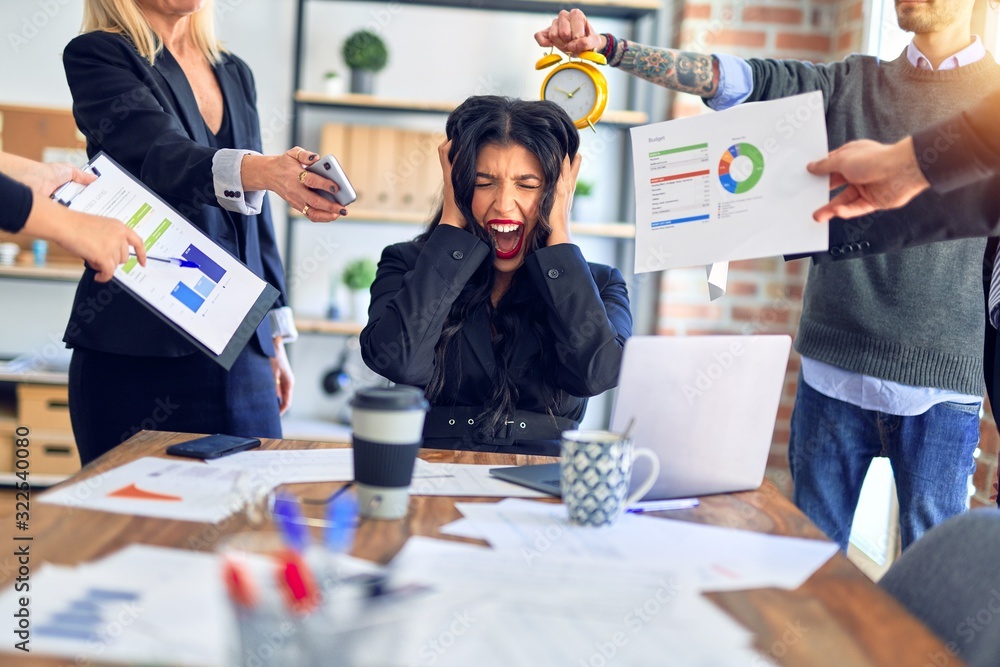 Fototapeta premium Group of business workers working together. Partners stressing one of them at the office