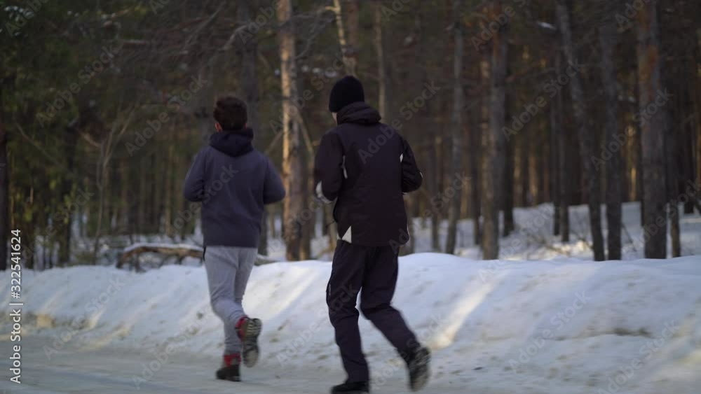 Young Male Athlete Jogging In Wintry Wood Young Male Athlete Jogging In Wintry Wood