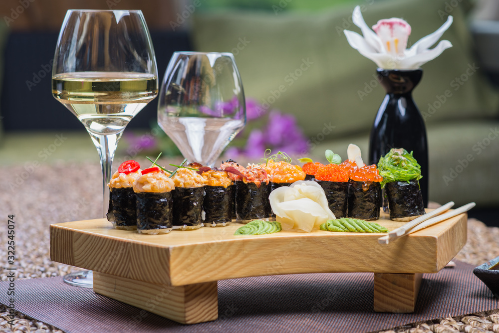Set of several different rolls on a wooden stand on a table in a Japanese restaurant. Japanese traditional sushi and rolls. Set of several different rolls on a wooden stand on a table in a Japanese restaurant. Japanese traditional sushi and rolls.