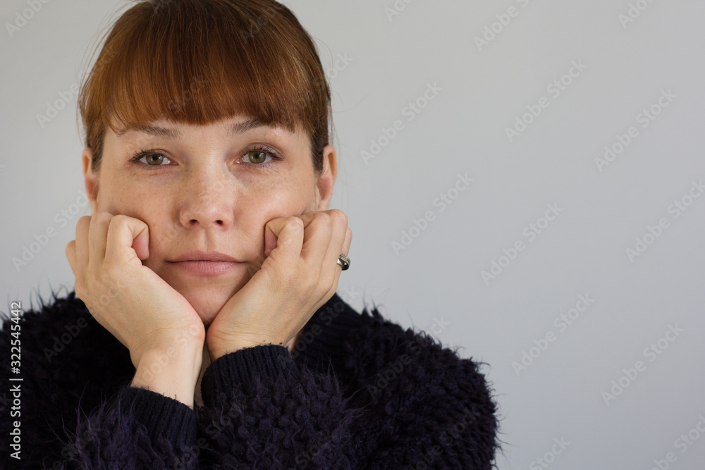 Φωτογραφία Portrait of the cute middle aged woman holding her hands close to face and looki