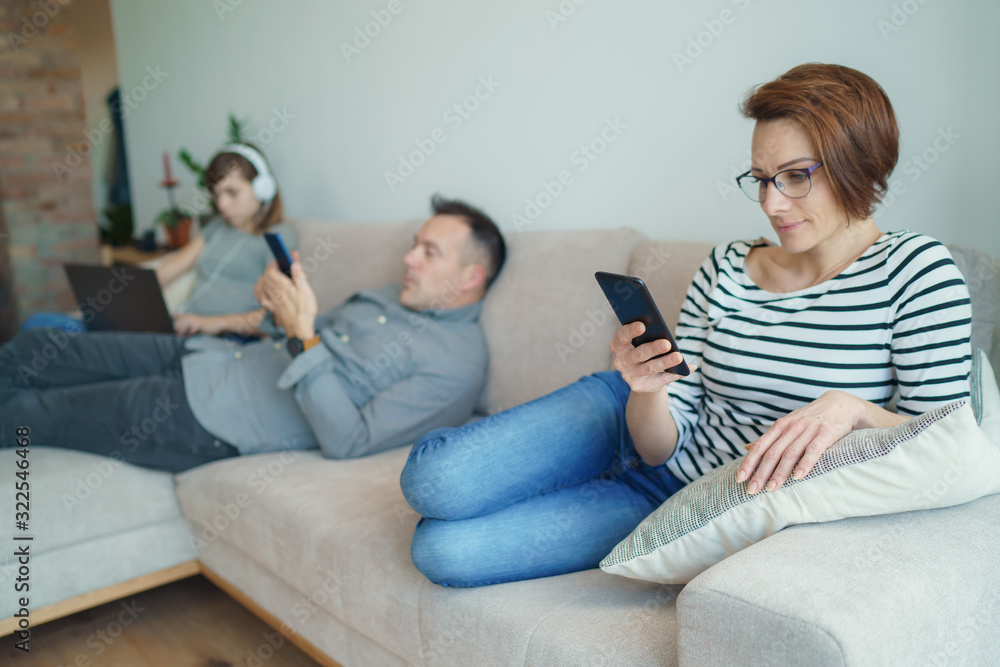 Technology addicted family: parents and child use laptop and mobile phones. Modern family values - Mom, dad with daughter obsessed with devices overuse social media, internet addiction concept.