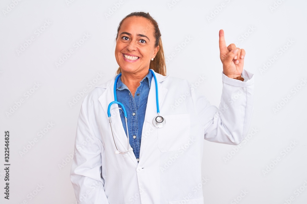 Middle age mature doctor woman wearing stethoscope over isolated background showing and pointing up with finger number one while smiling confident and happy.