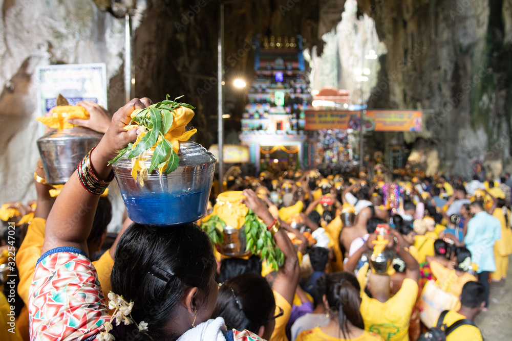 Naklejka premium Hindu devotees entering Batu Caves during Thaipusam festival in Kuala Lumpur, Malaysia. Selective focus on woman on the left. Bokeh effect.