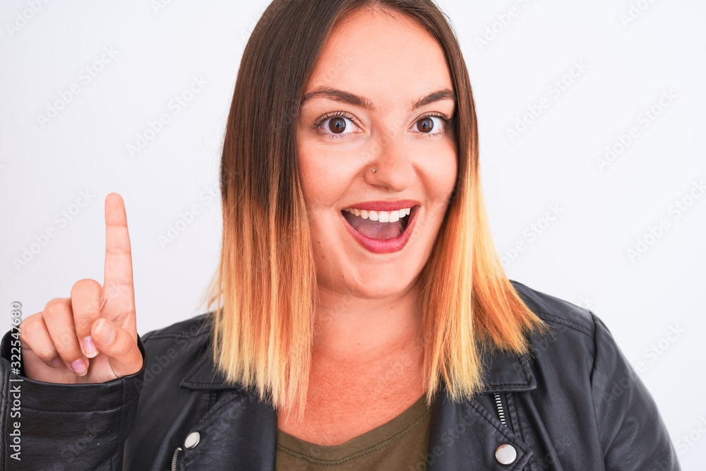 Young beautiful woman wearing t-shirt and jacket standing over isolated white background surprised with an idea or question pointing finger with happy face, number one Young beautiful woman wearing t-shirt and jacket standing over isolated white background surprised with an idea or question pointing finger with happy face, number one
