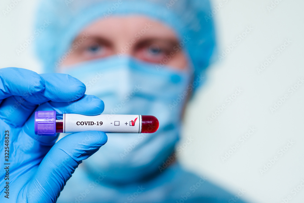 Medical laboratory assistant holding test tube with positive Coronavirus test blood sample. Medical laboratory assistant holding test tube with positive Coronavirus test blood sample.