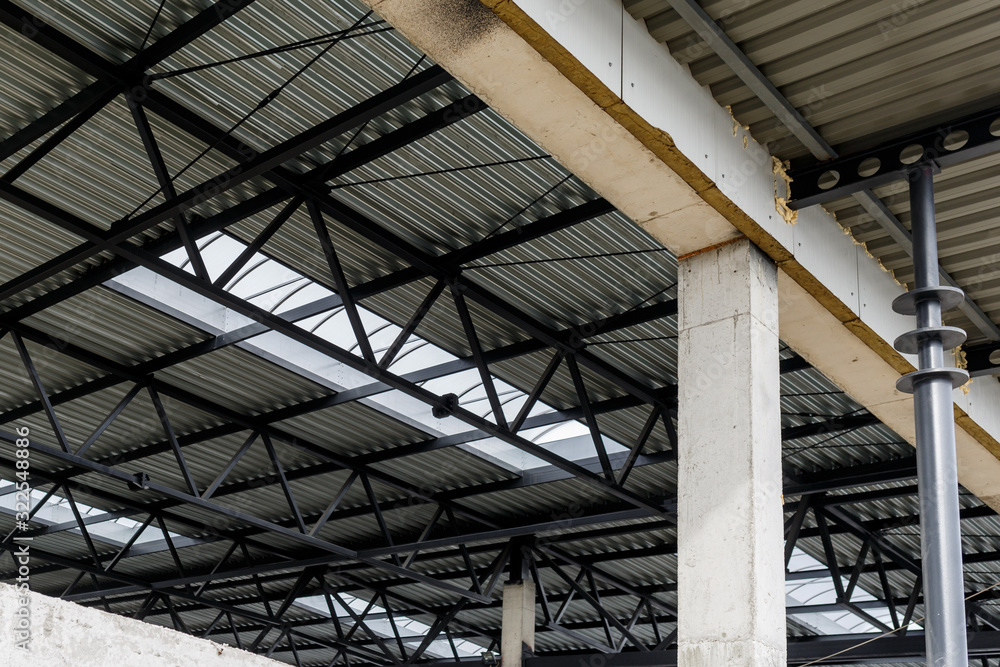 Aluminum roof with windows on a metal frame. Iron columns support the visor. Construction of the hangar. Aluminum roof with windows on a metal frame. Iron columns support the visor. Construction of the hangar.