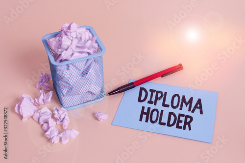 Word writing text Diploma Holder. Business photo showcasing a demonstrating successfully completed a particular course of study crumpled paper trash and stationary with note paper placed in the trash photo