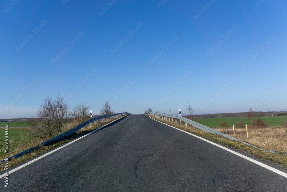 empty asphalt road to the horizon, cloudless blue sky, in Germany near Dresden empty asphalt road to the horizon, cloudless blue sky, in Germany near Dresden