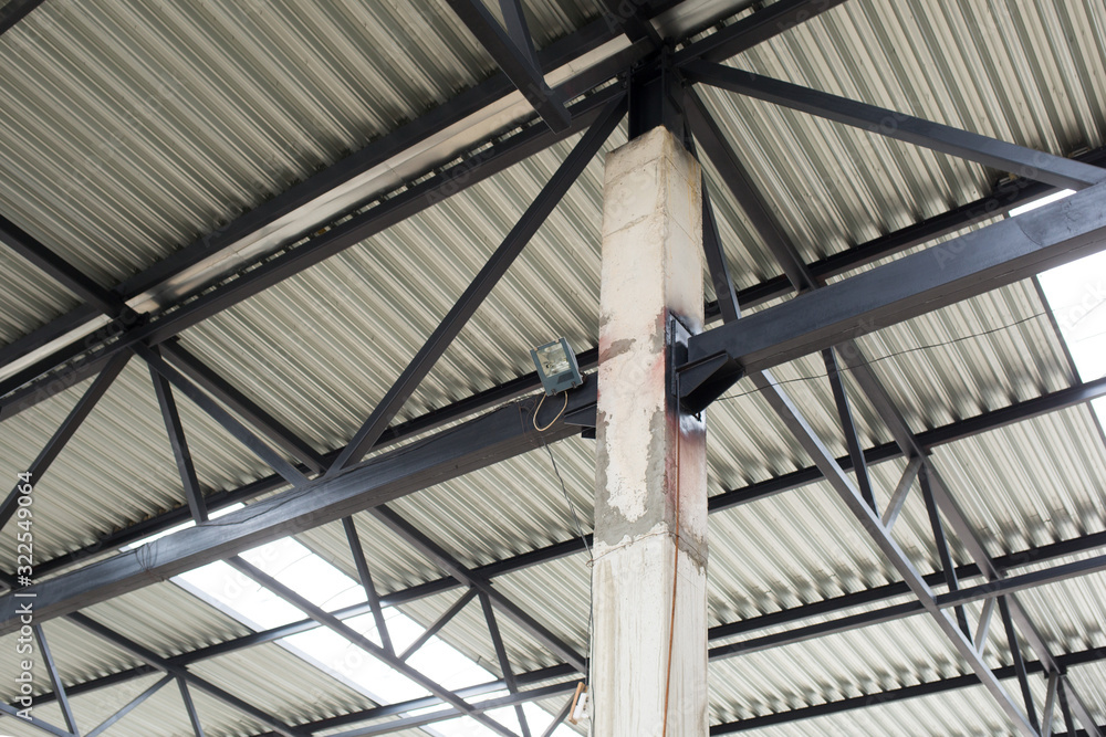 Aluminum roof with windows on a metal frame. A concrete column holds the structure. Construction of the hangar. Aluminum roof with windows on a metal frame. A concrete column holds the structure. Construction of the hangar.