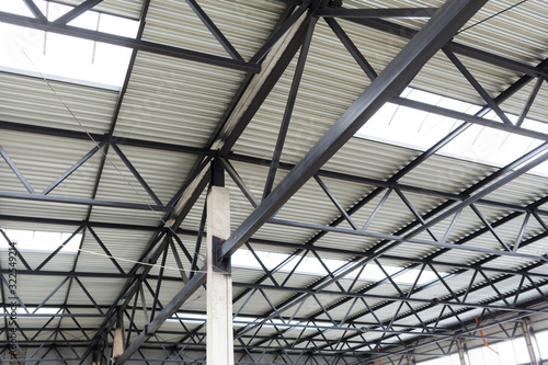 Aluminum roof with windows on a metal frame. A concrete column holds the structure. Construction of the hangar.