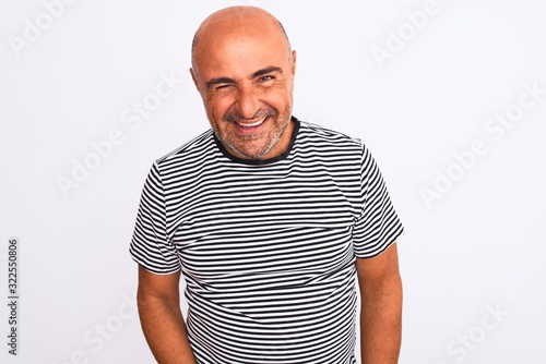 Middle age handsome man wearing striped navy t-shirt over isolated white background winking looking at the camera with sexy expression, cheerful and happy face.