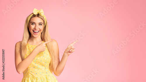 Happy teenage girl looking and pointing away at free space