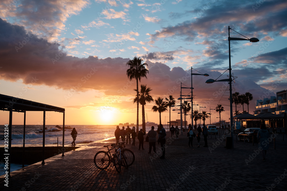 People enjoy the sunset on the main promenade in the city. Paphos, Cyprus.