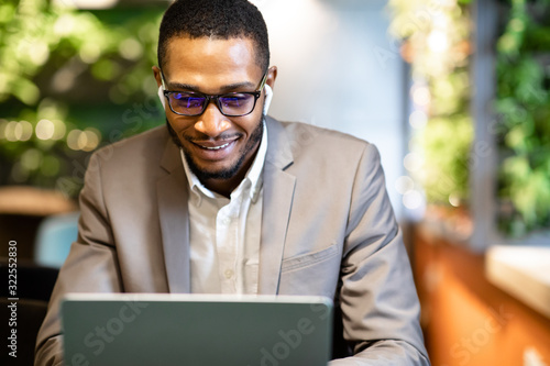 Portrait of afro guy using pc listening to music