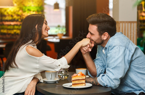 Loving Boyfriend Kissing Girlfriend's Hand Having Date In Cafe