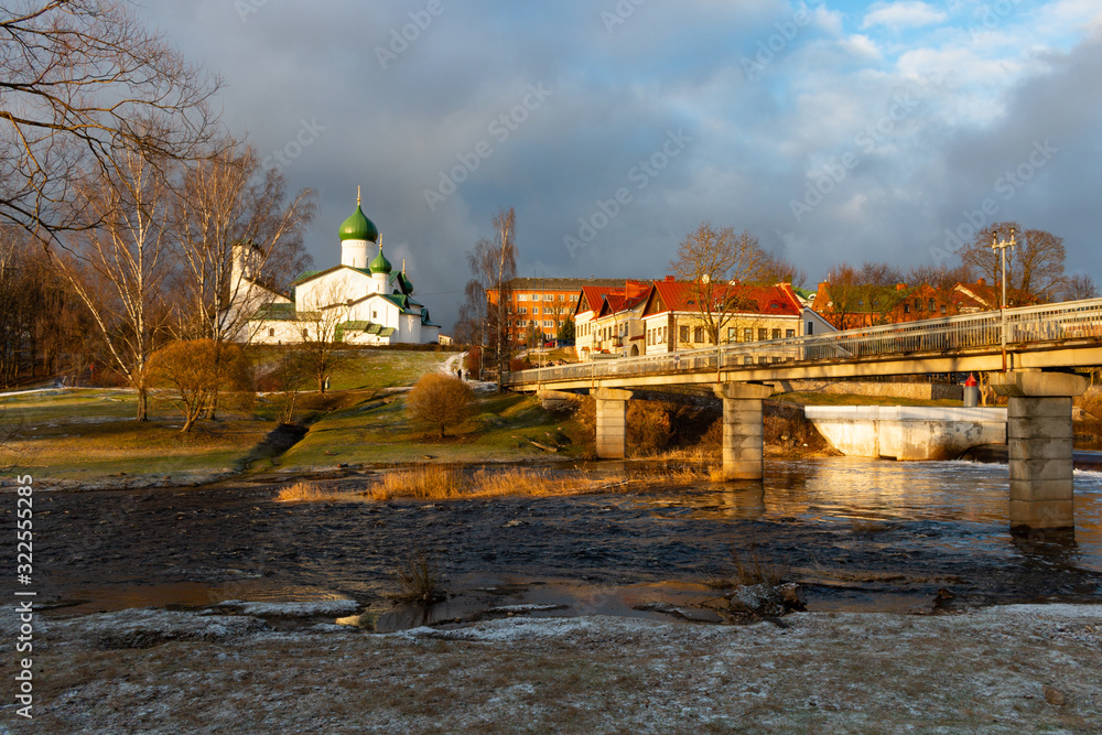 Typical Russian orthodox Church of the Epiphany on the Pskova river and the pedestrian bridge at the Kuopio park at Pskov, Russia at winter Typical Russian orthodox Church of the Epiphany on the Pskova river and the pedestrian bridge at the Kuopio park at Pskov, Russia at winter