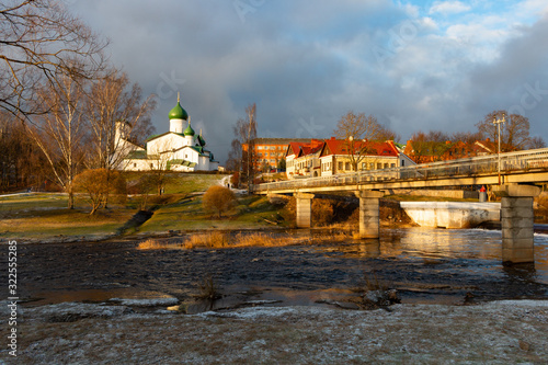 Typical Russian orthodox Church of the Epiphany on the Pskova river and the pedestrian bridge at the Kuopio park at Pskov, Russia at winter