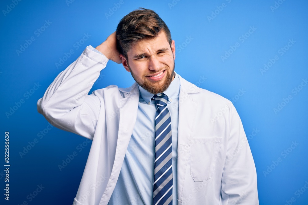 Young blond therapist man with beard and blue eyes wearing coat and tie over background confuse and wonder about question. Uncertain with doubt, thinking with hand on head. Pensive concept. Young blond therapist man with beard and blue eyes wearing coat and tie over background confuse and wonder about question. Uncertain with doubt, thinking with hand on head. Pensive concept.