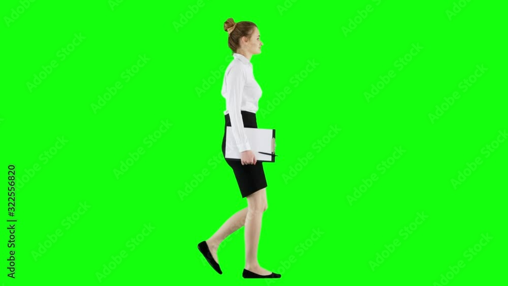 Young Brunette Businesswoman Walking With a Clipboard on Green Screen Young Brunette Businesswoman Walking With a Clipboard on Green Screen