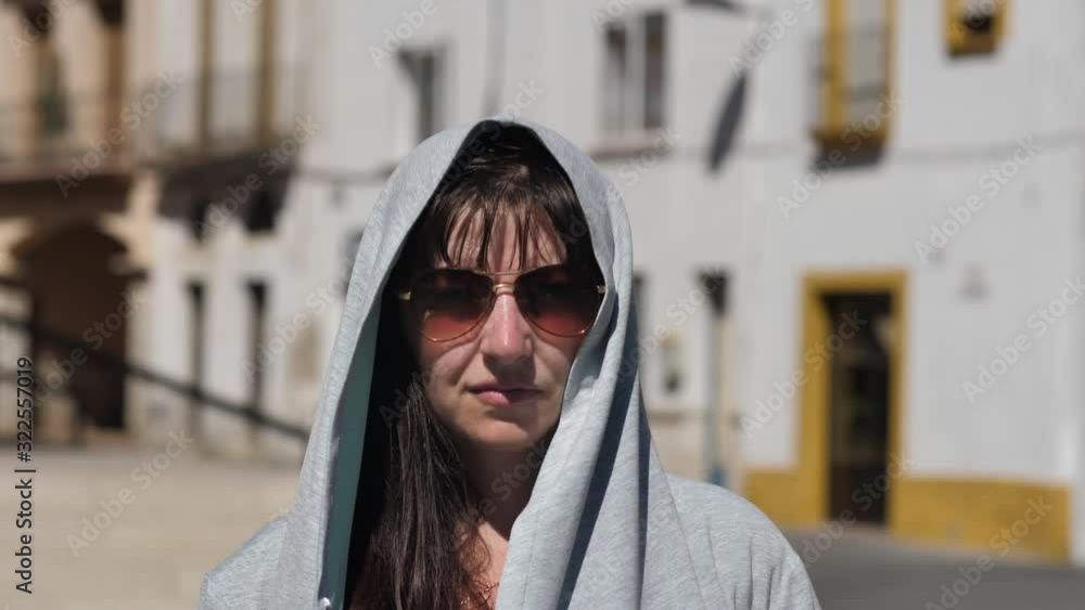 portrait of a woman in a hood looking at the camera outdoors portrait of a woman in a hood looking at the camera outdoors