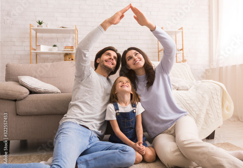 Foto Caring parents making symbolic roof of hands above little daughter's head