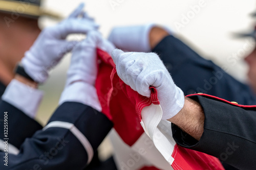 Soldiers fold an American Flag at a funeral for a Fallen Hero