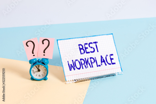 Text sign showing Best Workplace. Business photo showcasing helps employees to grow individually Promotes meritocracy Mini size alarm clock beside a Paper sheet placed tilted on pastel backdrop