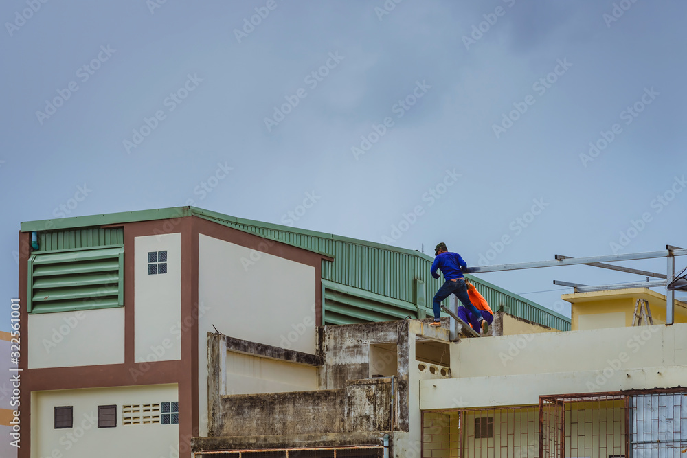 Worker welding the steel part for roof before it is going to rain. Worker welding the steel part for roof before it is going to rain.
