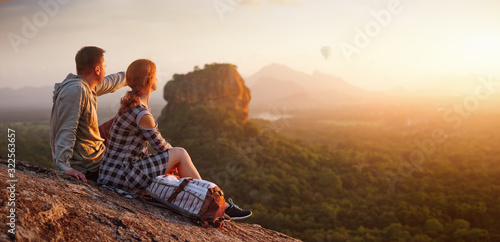 couple travelers watch a beautiful sunset near the famous rocky plateau Lion peak, Sigiriya. Sri Lanka