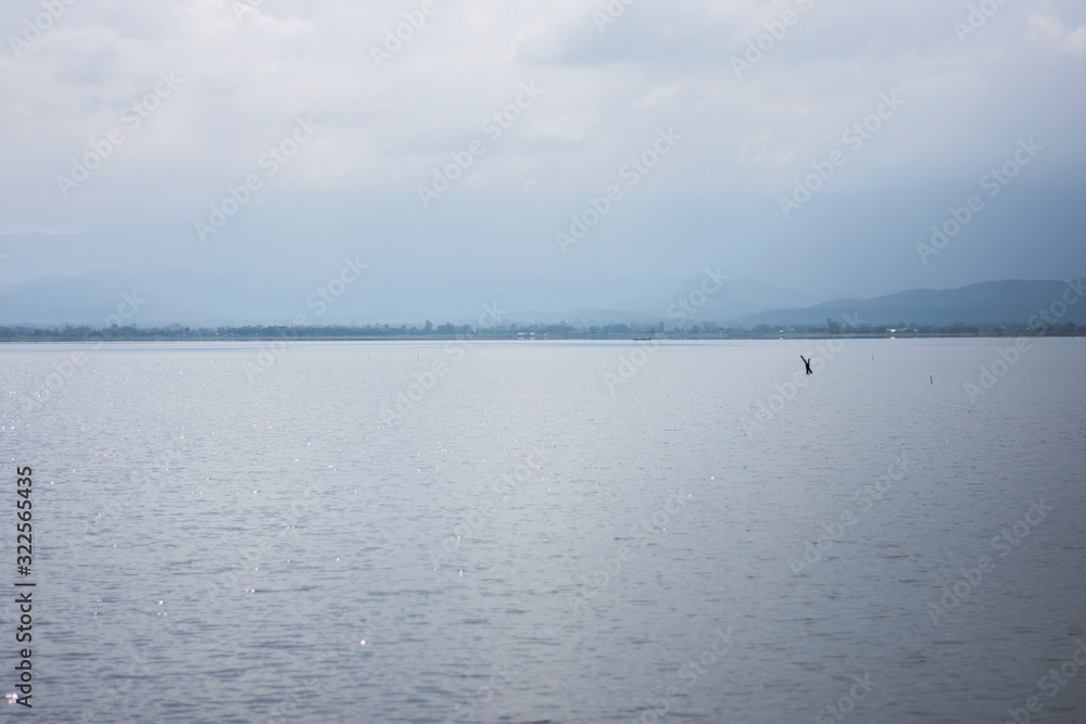 Clear sky clouds background mountains and lakes fresh water (Kwan Phayao, one of the famous tourist attractions of Phayao Province) in Phayao, Thailand