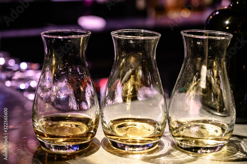 Flight of Scottish whisky  tasting glasses with variety of single malts or blended whiskey spirits on distillery tour in pub in Scotland
