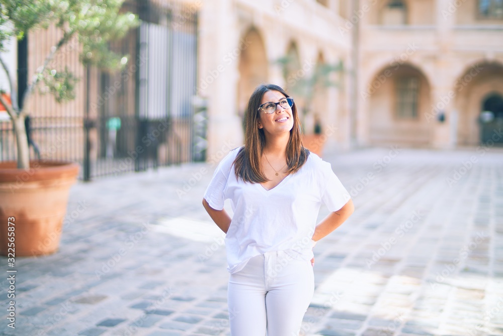 Young beautiful woman smiling happy and confident. Standing with smile on face at the town street Young beautiful woman smiling happy and confident. Standing with smile on face at the town street