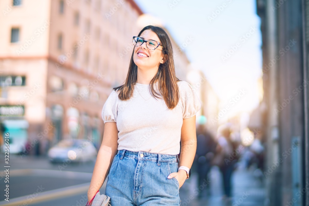 Young beautiful woman smiling happy and confident. Standing with smile on face at the town street