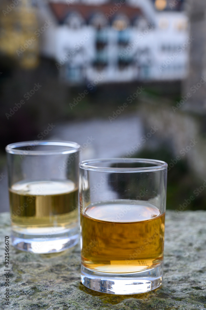 Scotch single malts or blended whisky spirits in glasses with old houses of Edinburgh on background, Scotland, UK Scotch single malts or blended whisky spirits in glasses with old houses of Edinburgh on background, Scotland, UK