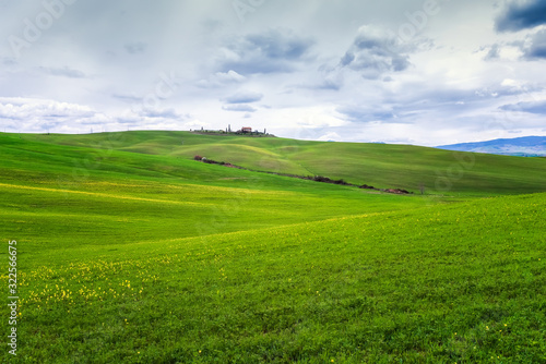Amazing Tuscany landscape with green rolling hills in spring cloudy morning