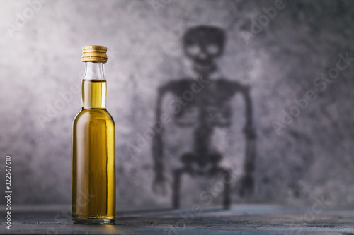 Canvas Print A bottle of whiskey with a shadow in the shape of a skeleton