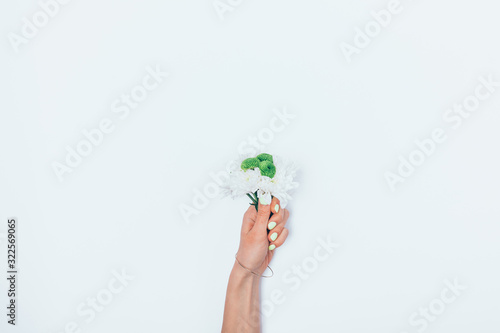 Bouquet of fresh flowers in female hand with manicure