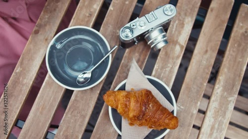 Tourist breakfast of coffee and croissant on a wooden table