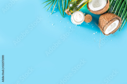 Coconut oil in glass jar with  tropical leaves and fresh coconut. Organic mct oils concept. turquoise, aquamarine background photo