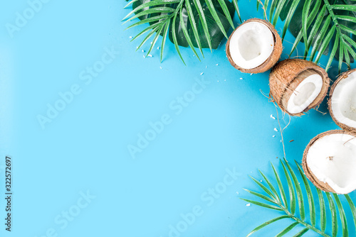 Tropical summer background with tropical palm leaves and coconuts, trendy turquoise, aquamarine background flatlay copy space